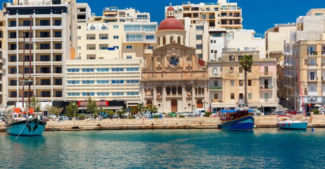 Quay of Silema with traditional Maltese church with red dome in the sunny day, Valletta, Capital city of Malta